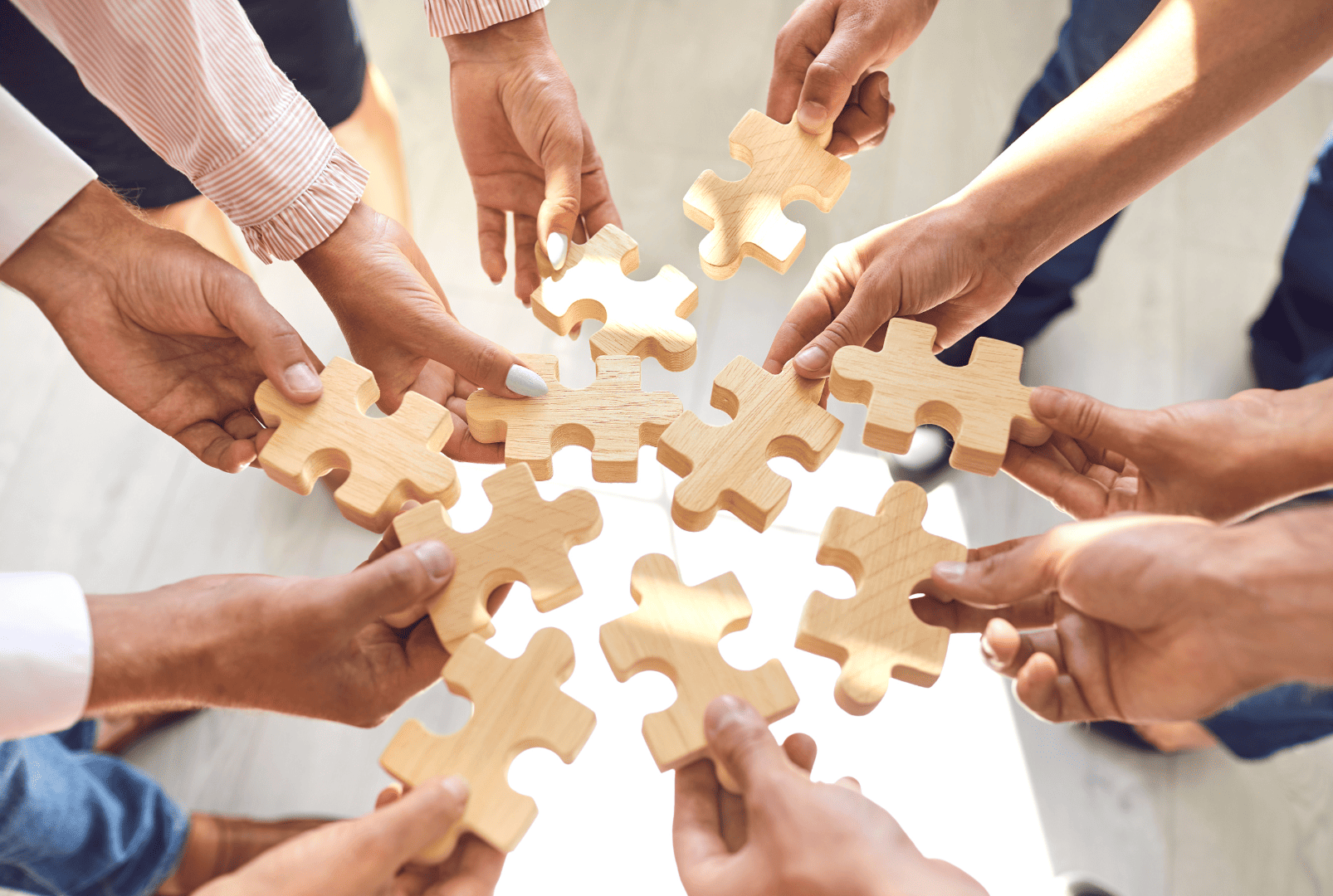 hands seen from below holding puzzle pieces